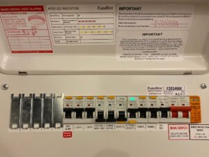 Newly installed consumer unit with clearly labeled circuits and safety instructions, ensuring electrical safety and compliance.